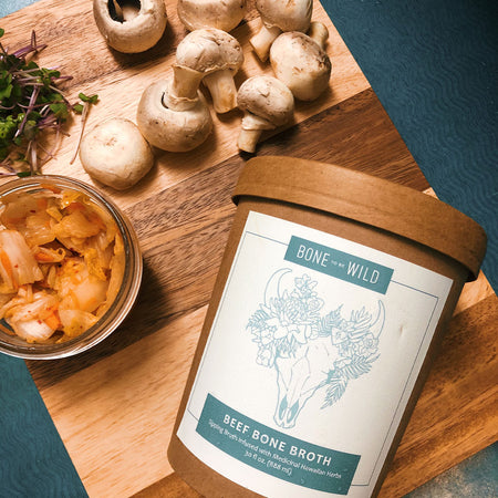 Cup of bone broth on a cutting board