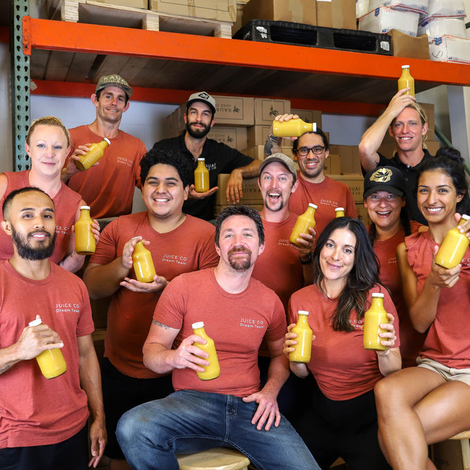 Back of house team members holding bottles of juice