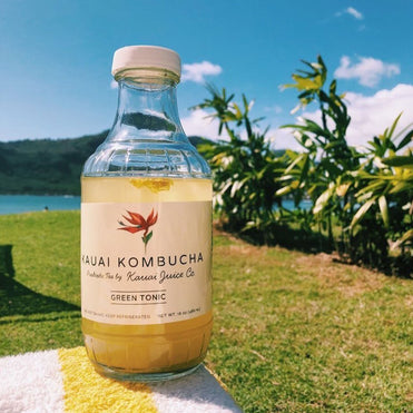 A bottle of kombucha on a table outside