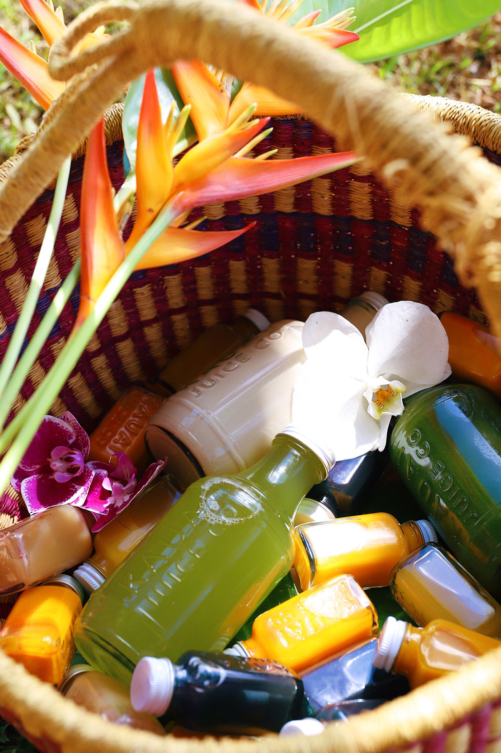 Bottles of elixers, kombucha, and juice in a basket
