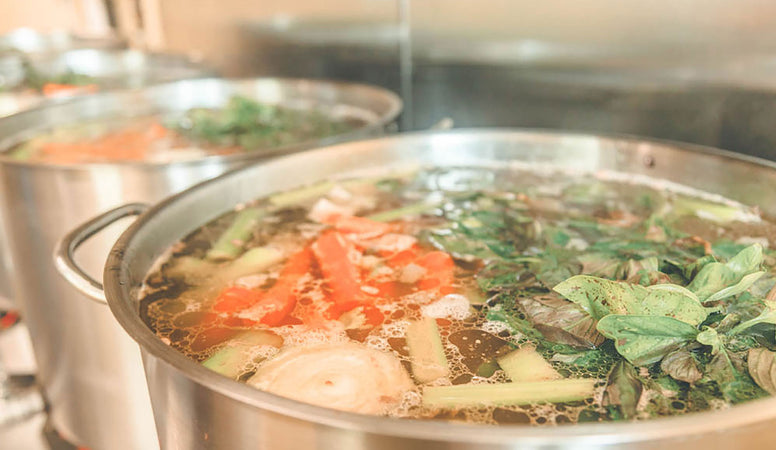 Veggies cooking in a pot of broth