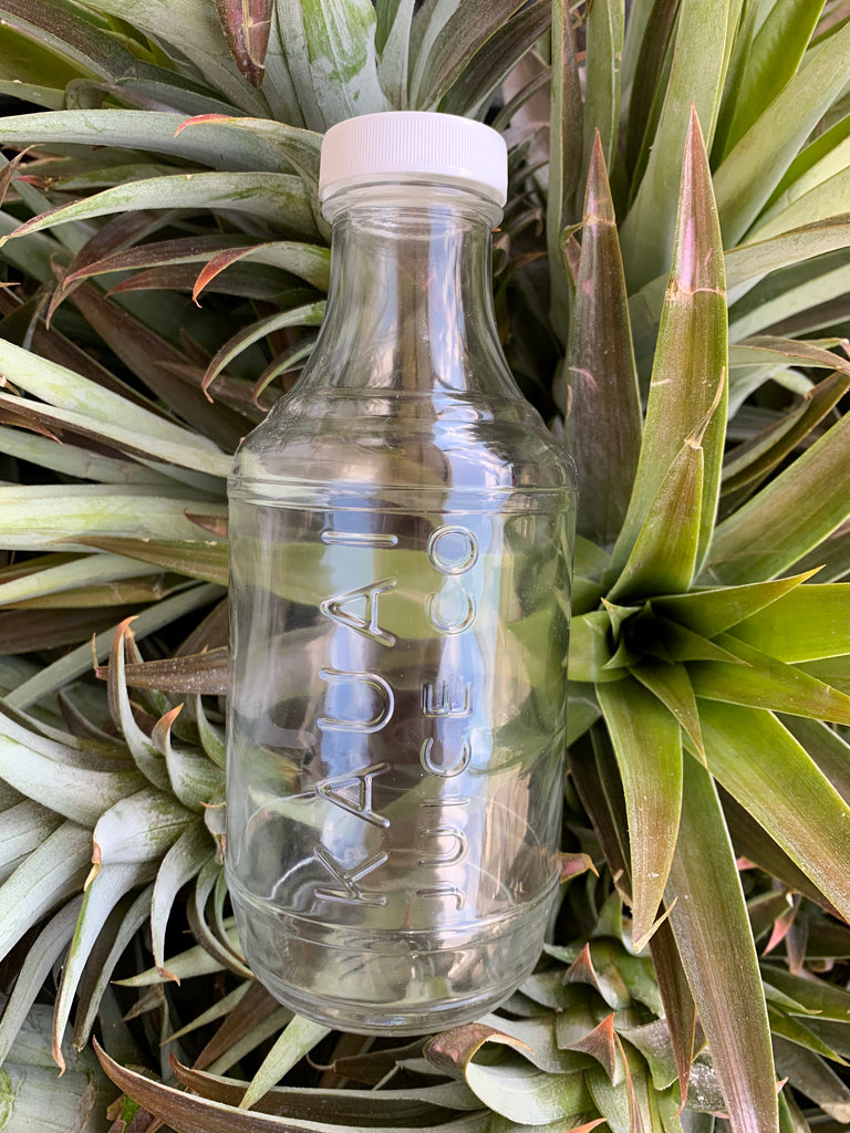clear Kauai Juice Co bottle on pineapples
