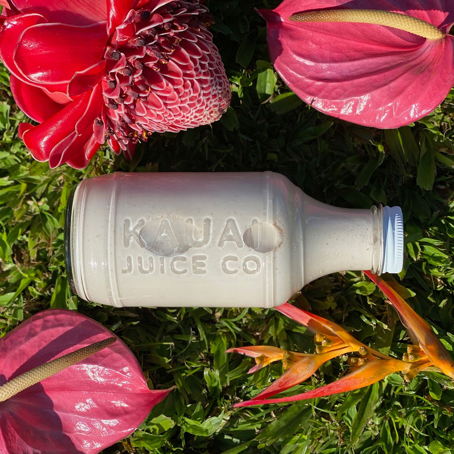 Bottle of juice surrounded by colorful flowers