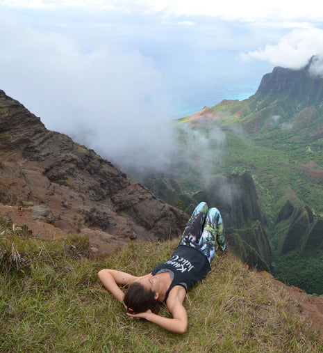 A woman laying down at the edge of a cliff