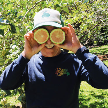 Farmer holding lemons up to his eyes