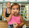 woman and child eating near refrigerated juice bar