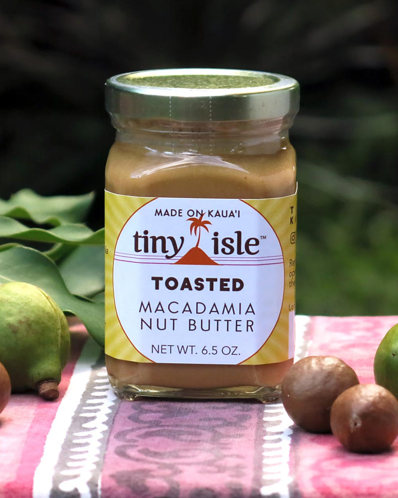 Jar of Tiny Isle Toasted Macadamia Nut Butter on table with macadamia nuts