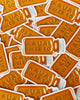 pile of orange hand drawn Kauai Juice Co jar stickers